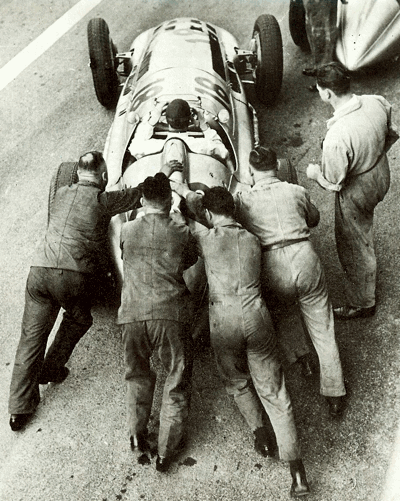 Four mechanics struggle to push start the 1939 W163 Mercedes-Benz of von Braughitsch at the French Grand Prix at Reims